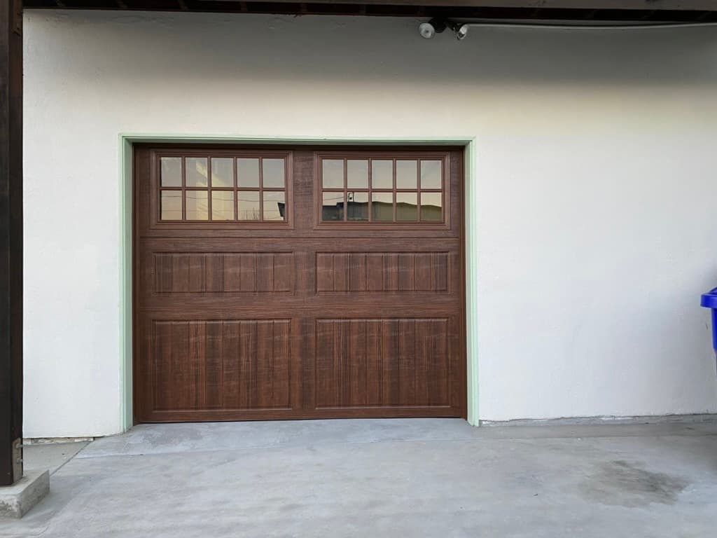 Walnut modern garage door with frosted windows during install, Bankers Hill